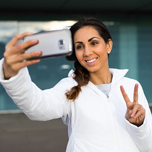 Successful fitness woman taking selfie with cell phone